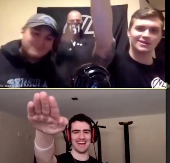 Screenshot of MacNeil on a video call giving the Nazi salute. He is with two other men, and they are all wearing clothes with the NSC 131 logo, and have an NSC 131 flag behind them. The person they are video-chatting with is wearing over the ear headphones and is smiling as he does the salute. 